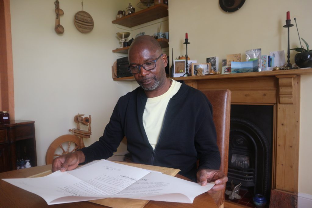 Olu Hyde examines wartime papers belonging to his father Adesanya Hyde, who served in RAF Bomber Command from 1941 to 1945. He was awarded the DFC in November 1944. Photo: H. Hughes.